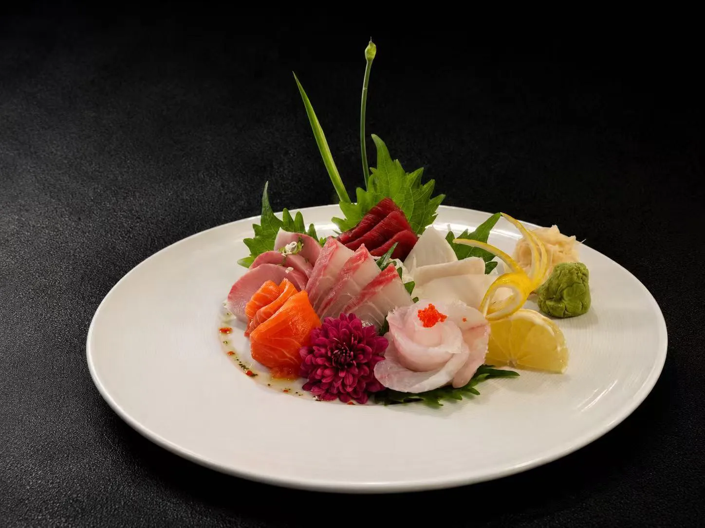 Assorted colorful sashimi platter with garnishes and lemon at Wasu Sushi Ramen, a Sushi restaurant in Bedminster